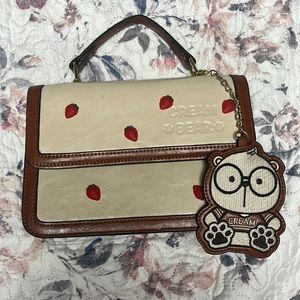 I am selling a cream bear bag with strawberry charms on the front